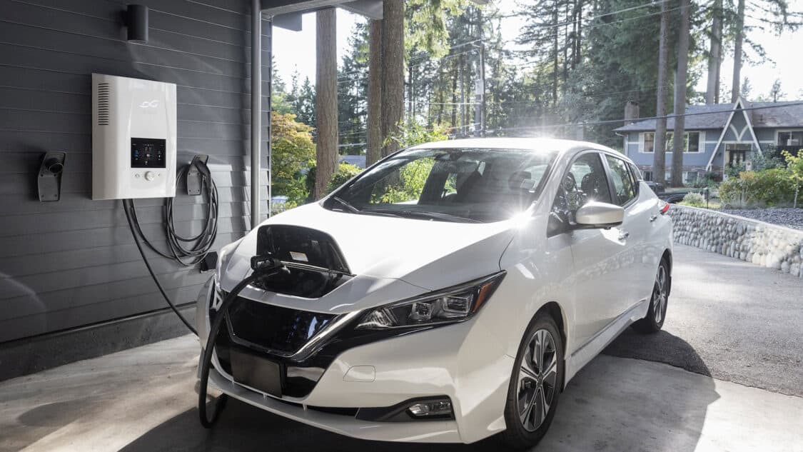 photo of nissan leaf parked with ev home charger plugged in