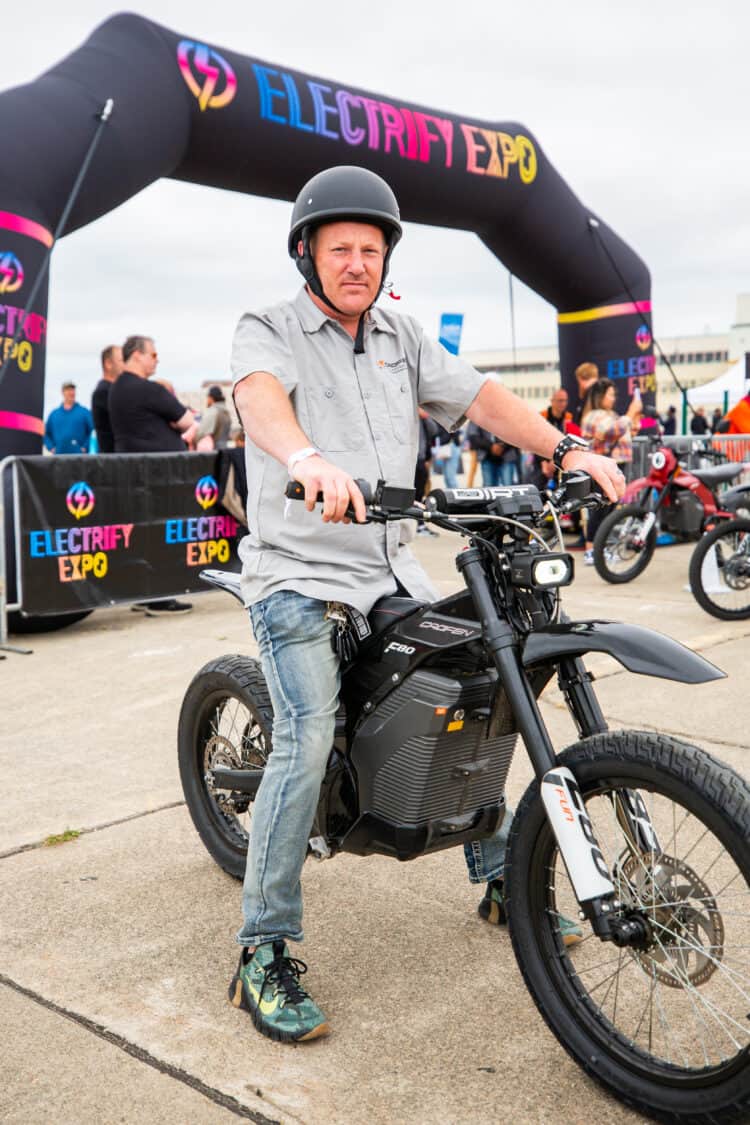 Photo of a man test riding a Caofen F90 electric bike at Electrify Expo