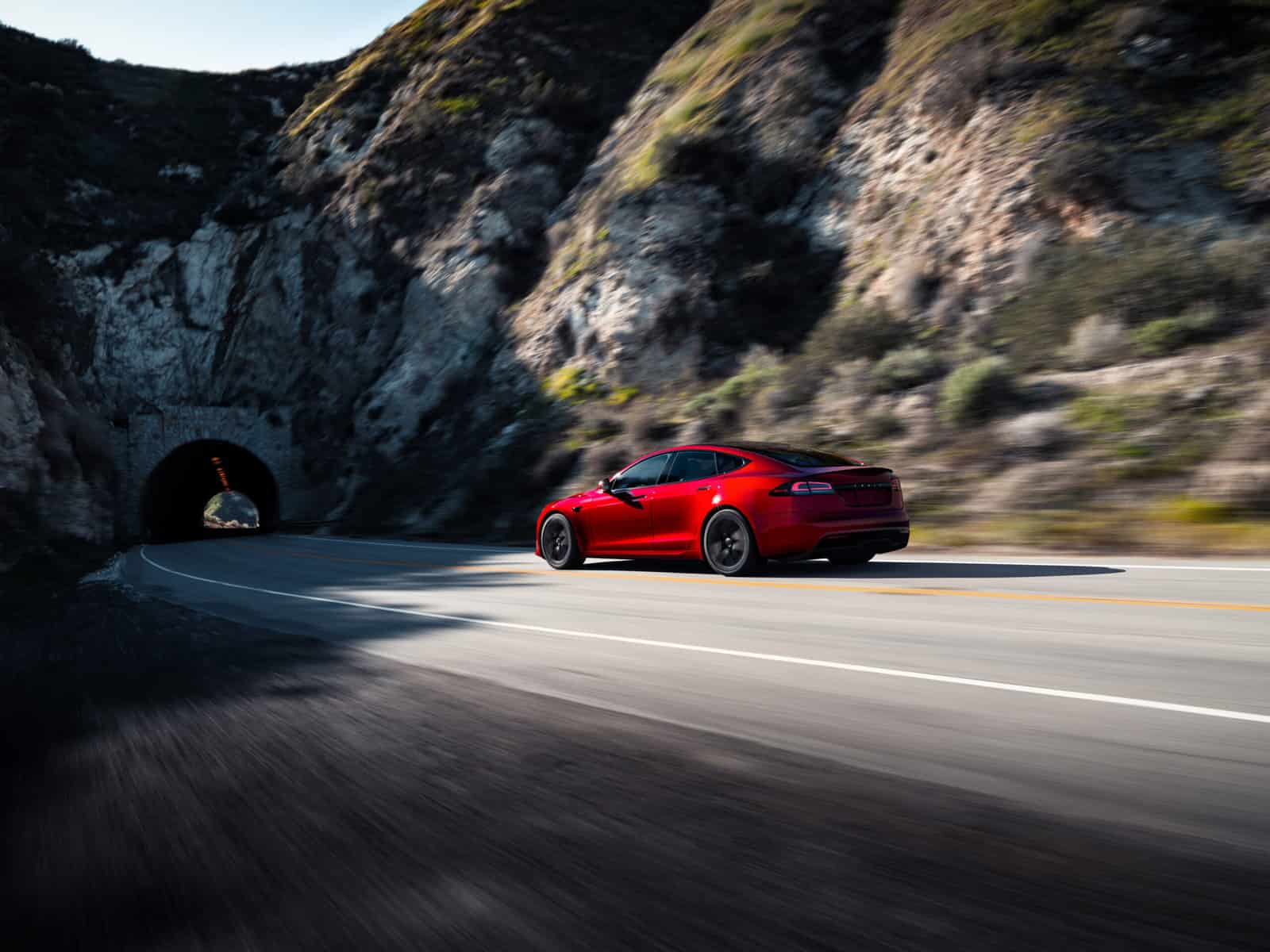 Tesla Model S red going into mountain tunnel