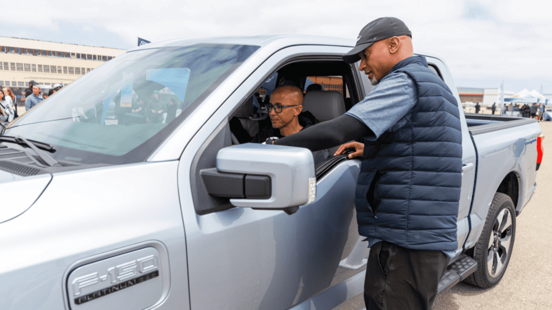 Photo of Ford employee showing customer the Ford F-150 Lightning Platinum features.