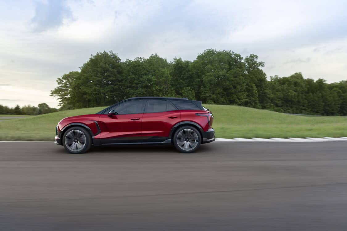 Photo of 2024 Chevrolet Blazer EV SS in Radiant Red Tintcoat driving on a road with trees. Preproduction model shown. Actual production model may vary. 2024 Chevrolet Blazer EV available Spring 2023.