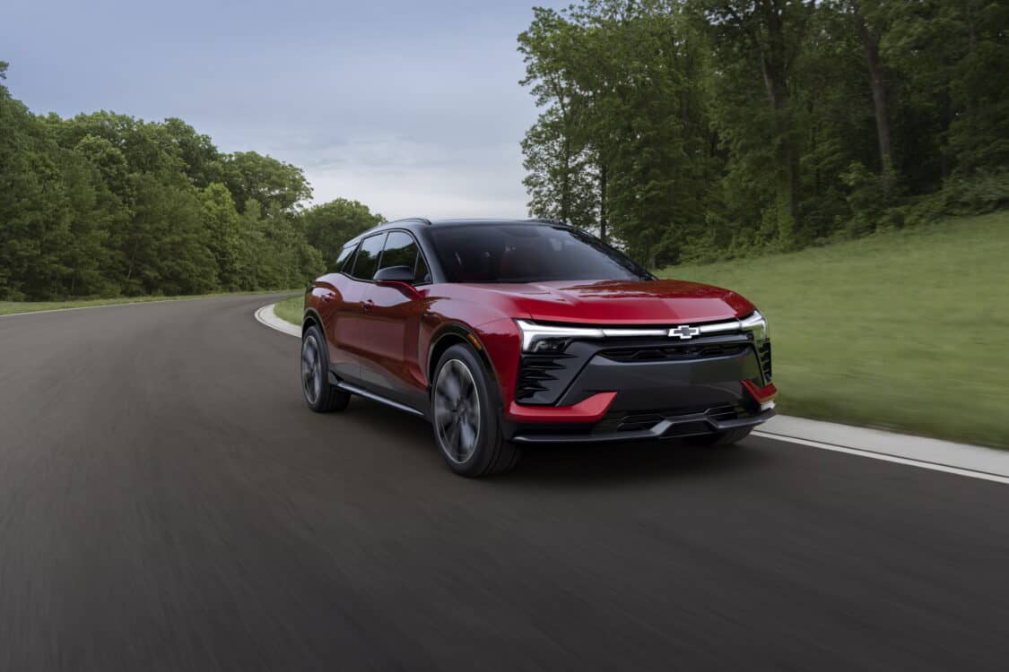 Photo of Passenger’s side view of the 2024 Blazer EV SS in Radiant Red Tintcoat driving on a road with trees. Preproduction model shown. Actual production model may vary. 2024 Chevrolet Blazer EV available Spring 2023.