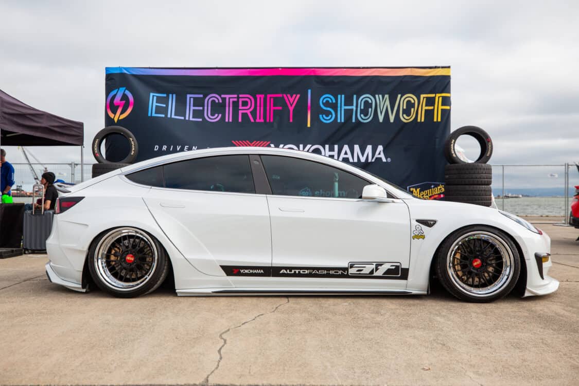 Photo of Americus Cuevas JDM VIP Bippu 2018 Tesla Model 3 LR RWD from Ruined EV modified with Thor Electronic Exhaust Management System (Dual), 12-Volt Battery (lithium) provided by Buddy Club USA – MEGALife Battery, 19” BBS LM Wheels, Yokohama Advan Sport V107 Tires - 235/35/19 (f), 255/35/19 (r), C7 6-Piston Brembo Brake Conversion/ 370 mm BBK by Don Marconi, Universal Air Suspension Struts, Air Lift 3P Management w/ 5 gal Seamless Air Tank, VIAIR 444c Compressors (2), LOSTAR Aluminum Magnesium Alloy Skid Plates, Artisan Spirits Sports Line Black Label EVS Widebody, WellVisors Window Visors, Carbon Fiber M3 Style Side Mirrors, Electric Speed Design Carbon Fiber Mud Guards, Electric Speed Design Carbon Fiber Door Handle Covers (Painted PPW), Electric Speed Design Carbon Fiber Side Marker Covers, Robot Craftsman Multi LED Taillights (1 of 2 in the world), LowGlow Undercar LED Kit, Ghozt Lighting Module, AutoFasion Window Curtains, Broadway Mirror 300mm Convex Wide, Junction Produce Carbon VIP Tables, Junction Produce Tsuna Knot (Silver), Junction Produce Fusa Shield Emblem (Bronze), Junction Produce Katana Shift Knob 20cm (Black), Junction Produce Hannya Charm (Red Mask), Junction Produce Kyoto Fan (Black/Red), Junction Produce Tissue Box Cover (Black), Junction Produce Crystal Ashtray (Round), Junction Produce Throw Pillow Cushion (Black), Junction Produce Seat Cushion (Black), Junction Produce Missions Neck Pad V1 (Black), Junction Produce x DAD VIP Air Freshener (Crown), Air Spencer Squash x4, Electric Speed Design Carbon Fiber Dash, Electric Speed Design Carbon Fiber Window and Door Switch Kit, Electric Speed Design Carbon Fiber Center Console kit, Electric Speed Design Carbon Fiber Armrest Cover, Electric Speed Design Carbon Fiber Dome Light Covers, Electric Speed Design Carbon Fiber Stalk Covers, Inch Empire Seat and Flooring (Wine Red), Aroham D-Line Yoke Steering Wheel, Opelite Optics 600 Stars with shooting stars, Suede headliner reupholstery, Orella Acoustics Tesla Model 3 Speaker Upgrade, Hansshow 7.2” Rear Entertainment & Climate Control Display