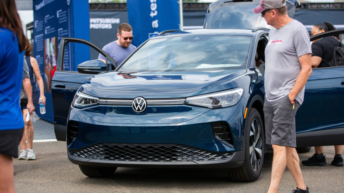 Volkswagen ID.4 at Electrify Expo with attendees exploring the vehicle.