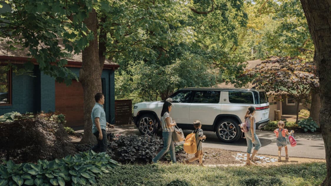 Americans will be forced to buy electric, family walking towards their parked Rivian EV