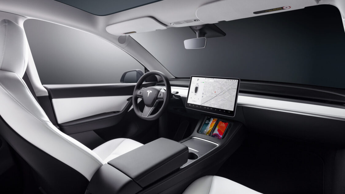 Photo of A 2023 Tesla Model Y interior, infotainment system, front driver seat, steering wheel