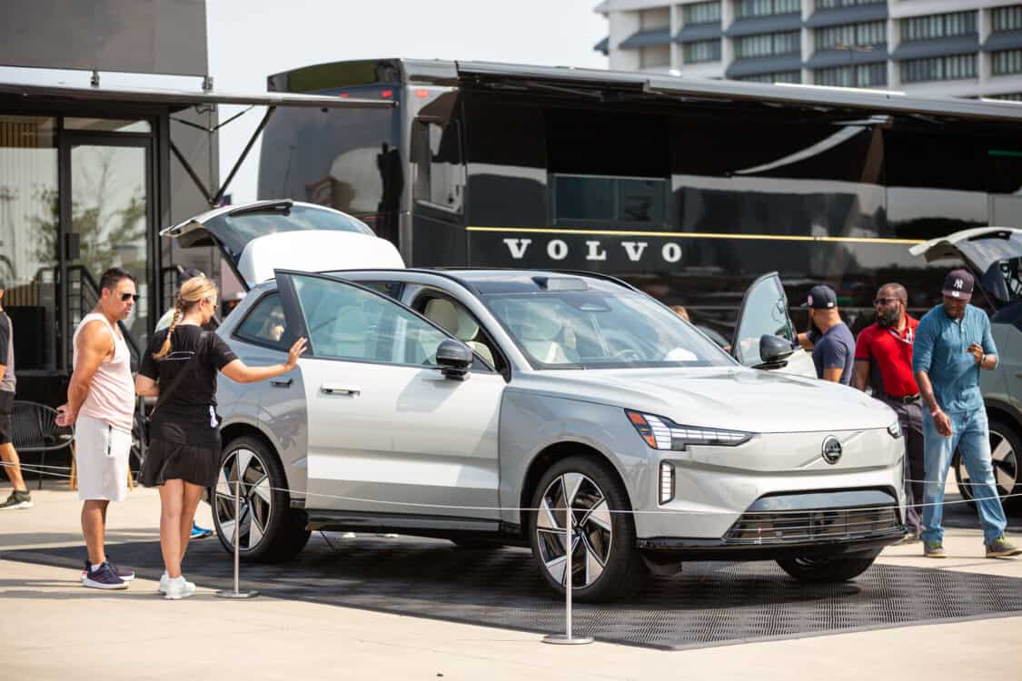 Photo of attendees looking at the features of a Volvo EX90 electric SUV at Electrify Expo in New York