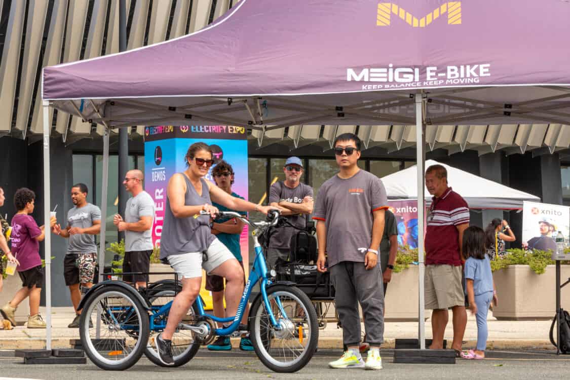 Photo of attendees test riding MEIGI electric bikes at Electrify Expo in New York
