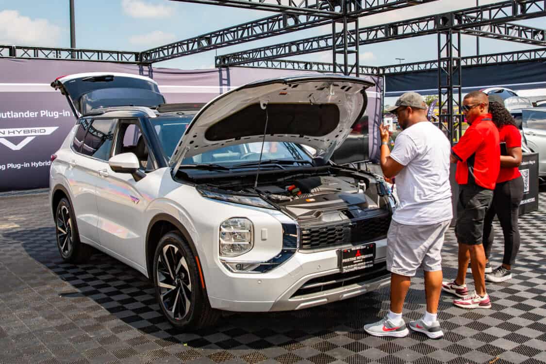 Photo of a man looking at the engine of a Mitsubishi Outlander at Electrify Expo in New York