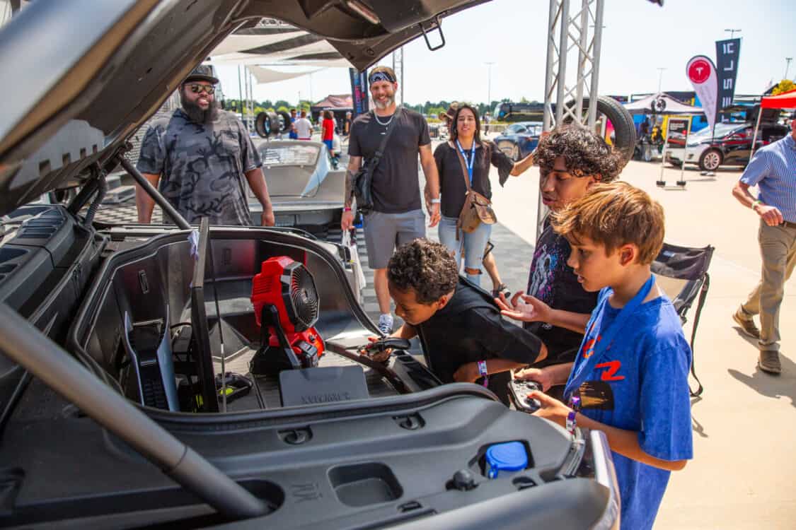Photo of kids playing video games in a Ford F-150 Lightning at the Toyo Tires booth at Electrify Showoff in New York