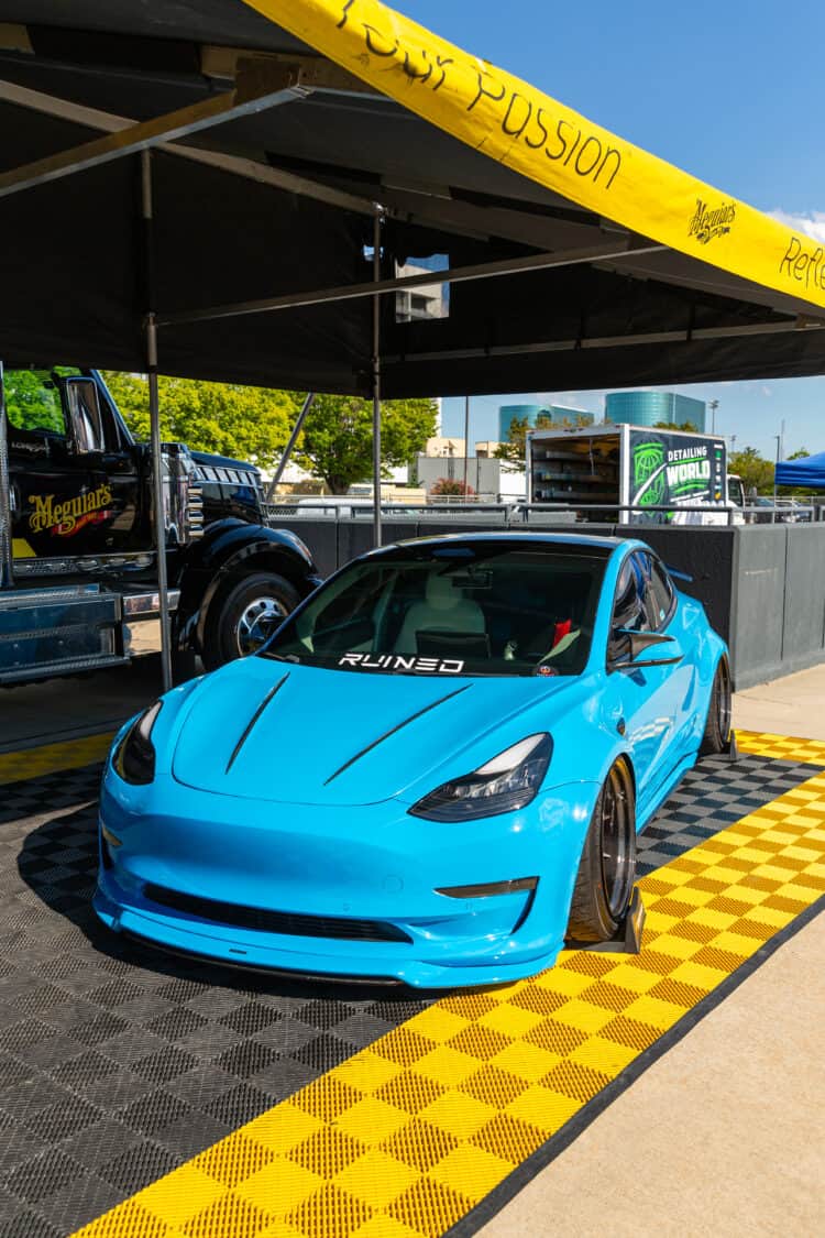 Image showcasing AJ Velasco's Tesla Model 3 in Meguiar's booth at Electrify Showoff New York