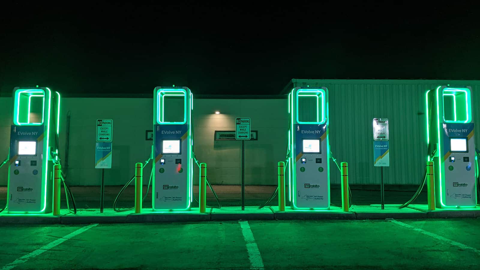 image showing you can find an Electrify America charging station at night easily as it's glowing green