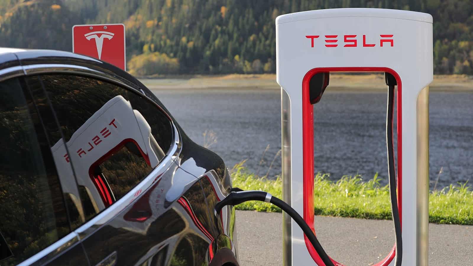 Tesla EV charging station with black car plugged in