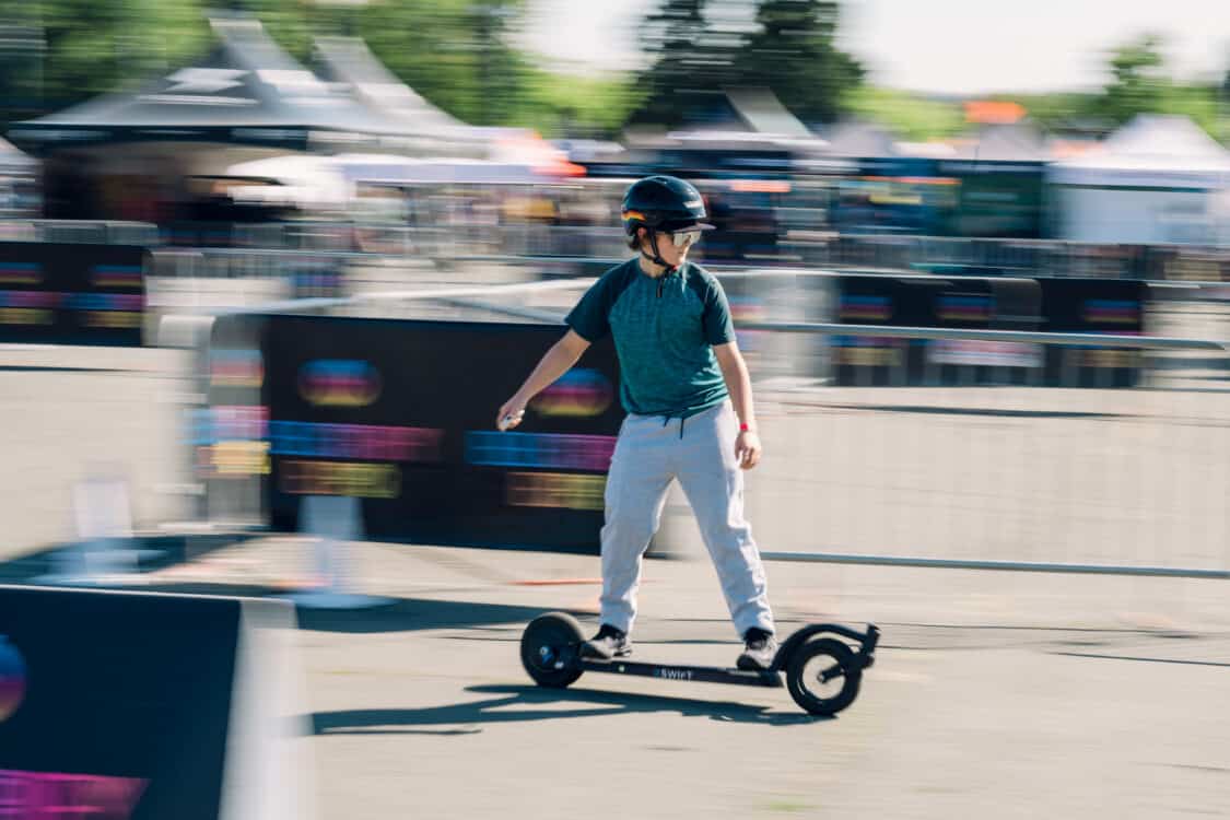 Image showcasing attendee riding 2swift skateboard at Electrify Expo Seattle