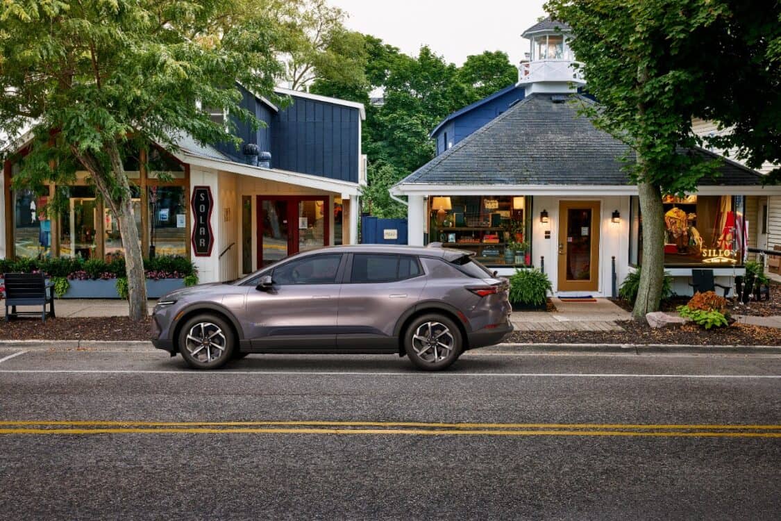 Driver’s side view of 2024 Chevrolet Equinox EV 1LT in Galaxy Gray Metallic parked on a street. EVs under $40K