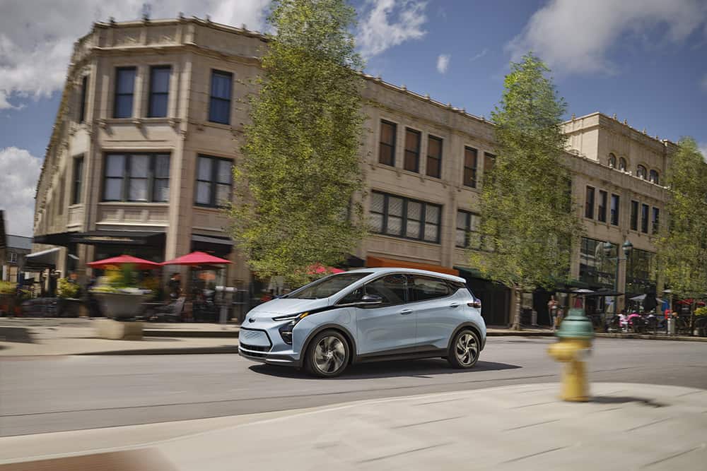 2023 Bolt EV side profile while driving on an urban city street