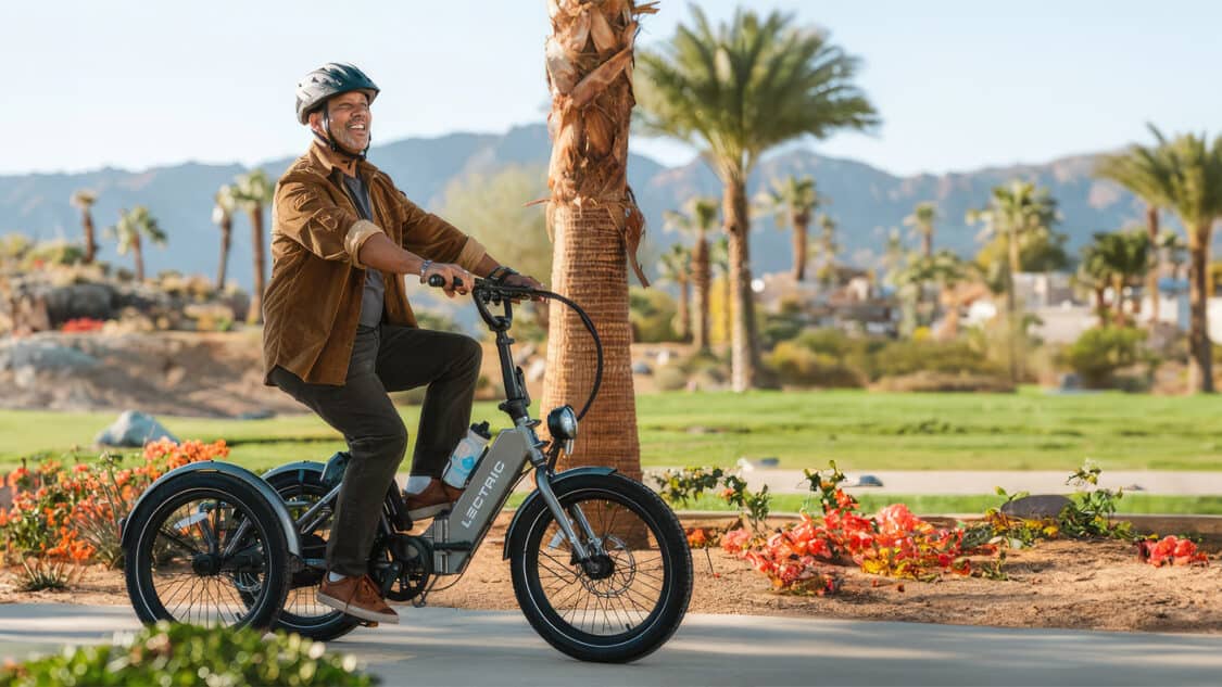 Man riding a Lectric Trike in a park with palm trees best electric tricycles