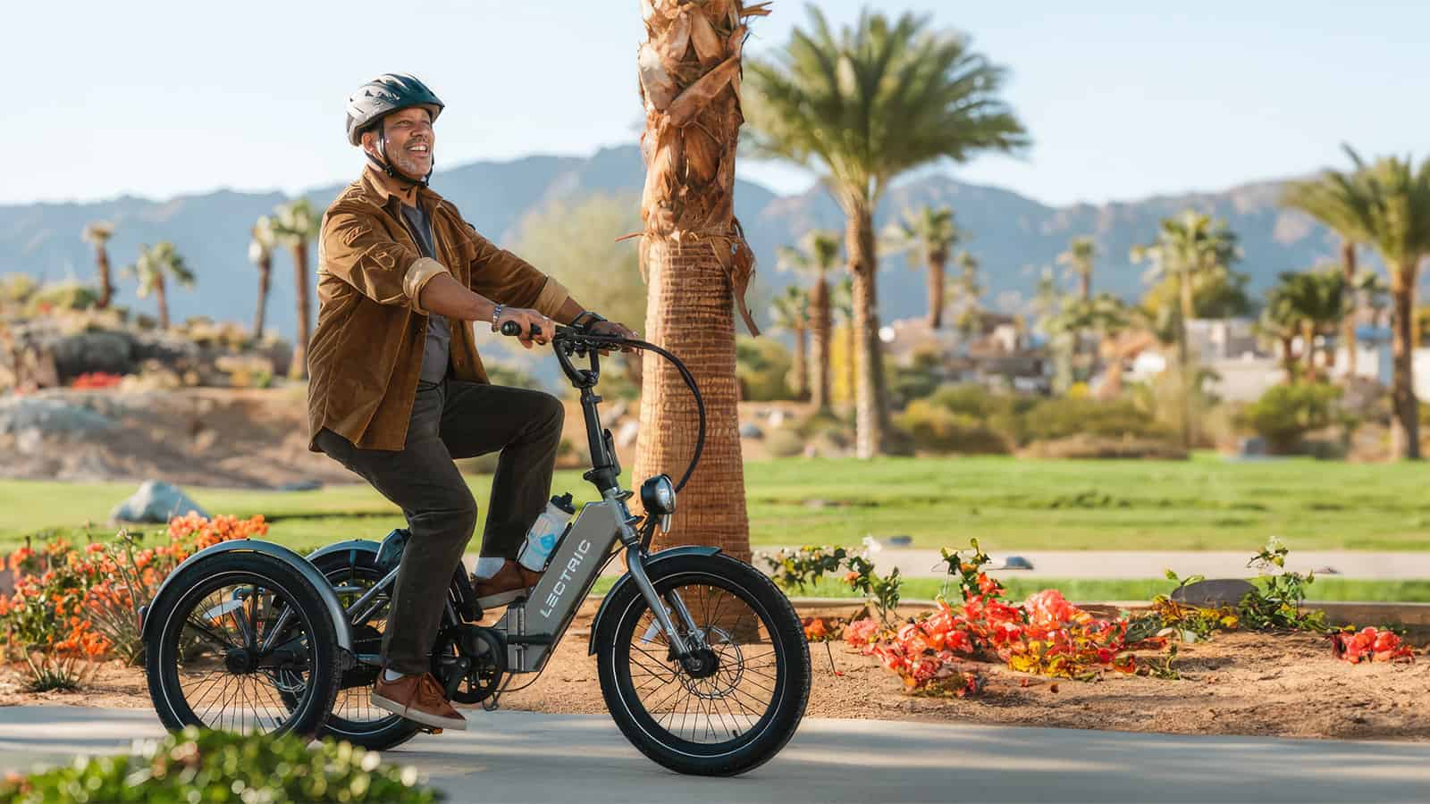 Man riding a Lectric Trike in a park with palm trees best electric tricycles