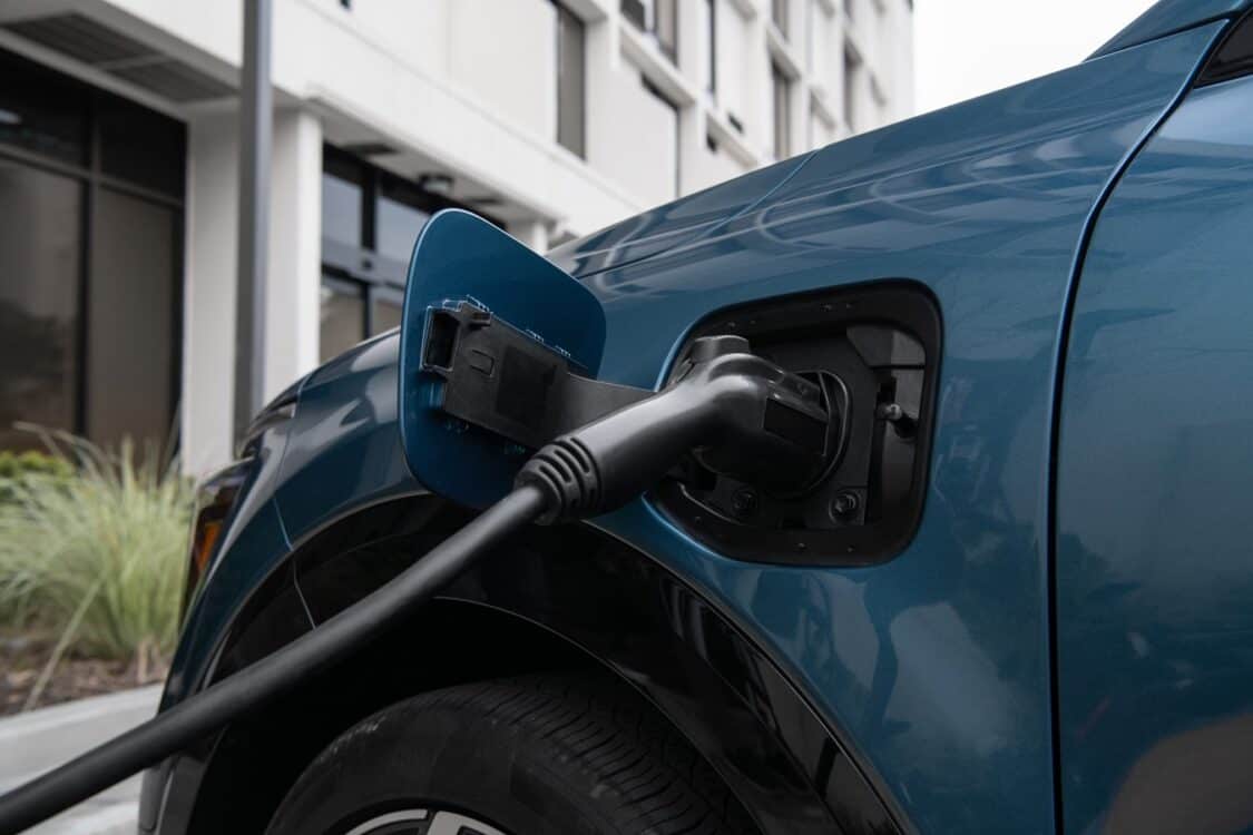 Blue Hyundai car plugged into non-NACS charger