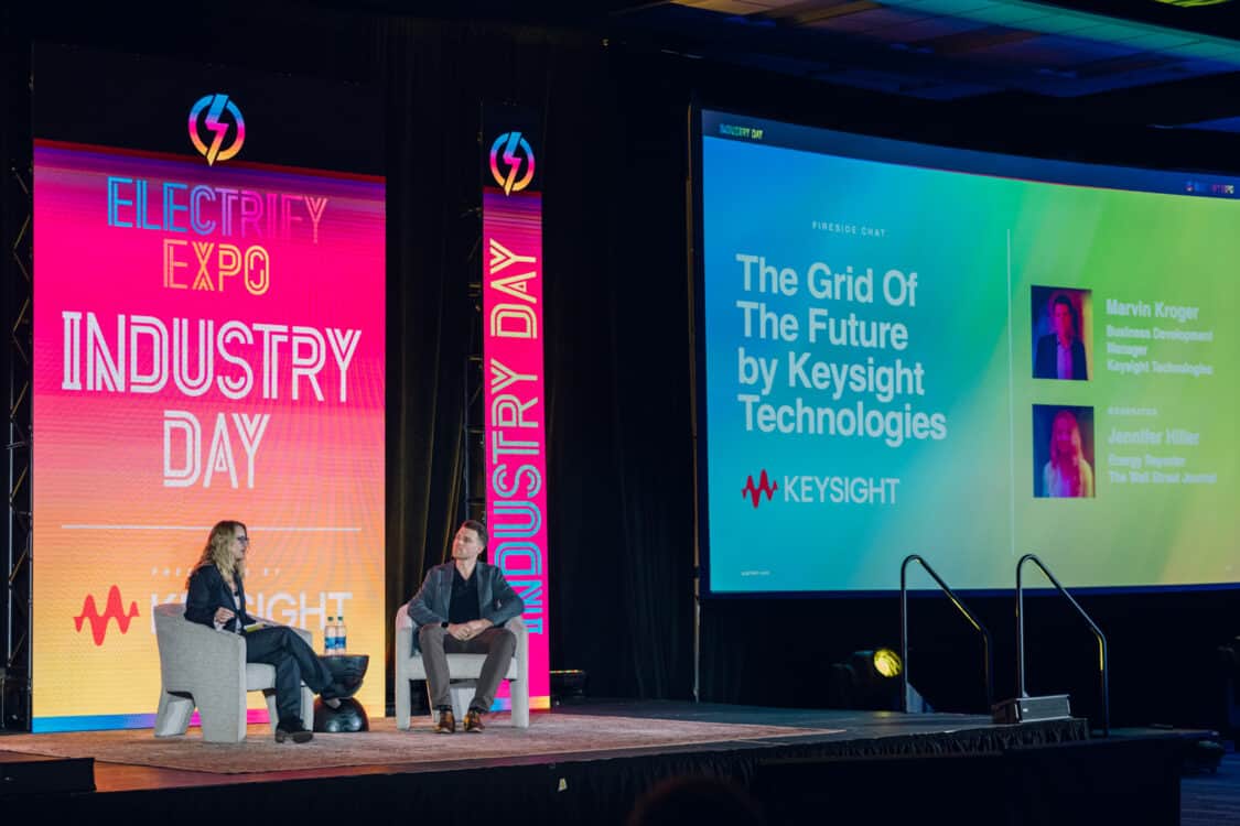 Image showcasing Marvin C. Kroger, Electric Vehicle Business Development Manager at Keysight Technologies, and Jennifer Hiller, Energy Reporter from The Wall Street Journal, engaged in a fireside chat about V2G technology at Electrify Expo Industry Day in Austin, TX 2023