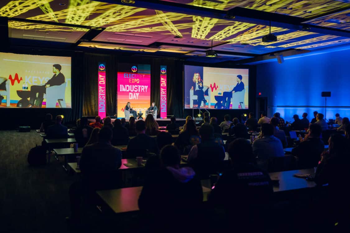 Image showcasing Marvin C. Kroger, Electric Vehicle Business Development Manager at Keysight Technologies, and Jennifer Hiller, Energy Reporter from The Wall Street Journal, engaged in a fireside chat about V2G technology at Electrify Expo Industry Day in Austin, TX 2023