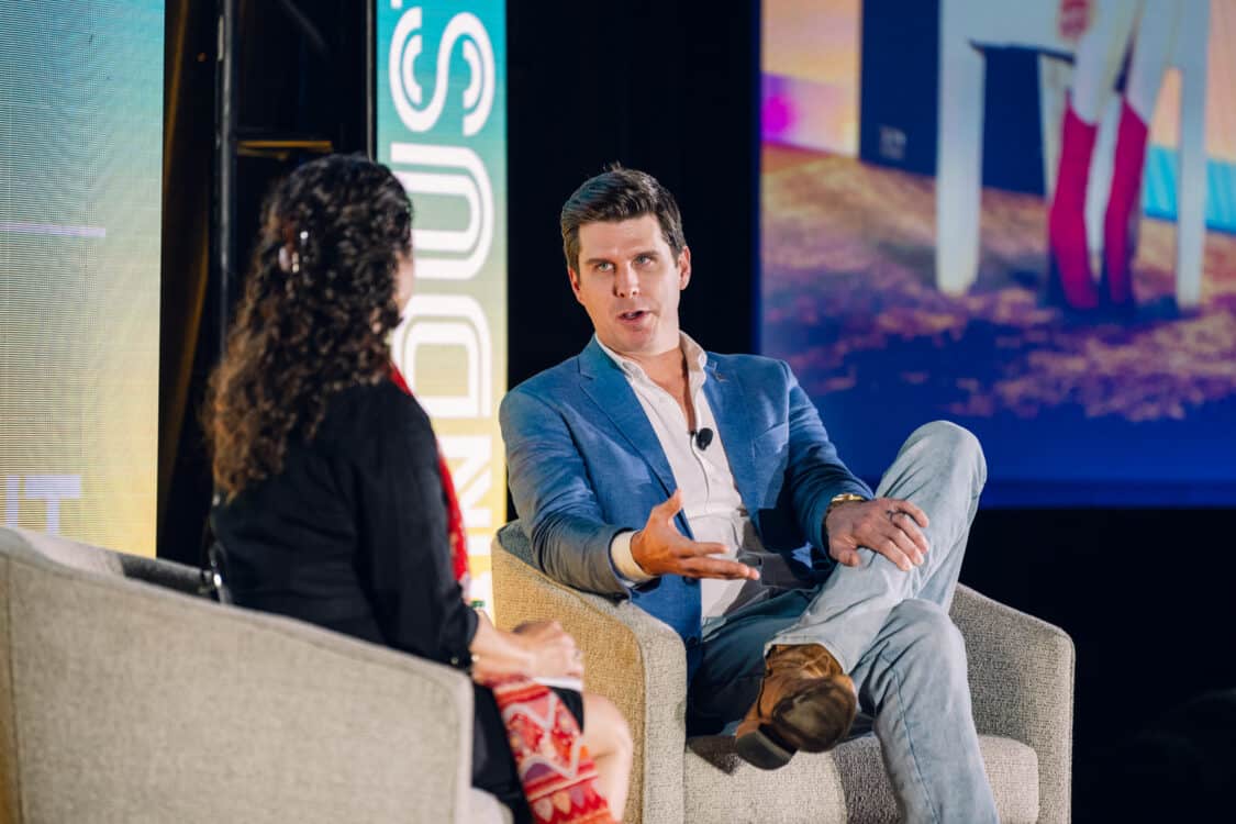 Image showcasing Sean Ackley, Head of Charging & Energy at VinFast, speaking with Automotive Journalist Kristin Shaw in a fireside chat at Electrify Expo Industry Day in Austin, TX 2023