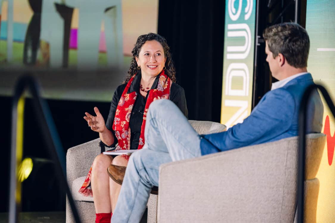 Image showcasing Sean Ackley, Head of Charging & Energy at VinFast, speaking with Automotive Journalist Kristin Shaw in a fireside chat at Electrify Expo Industry Day in Austin, TX 2023