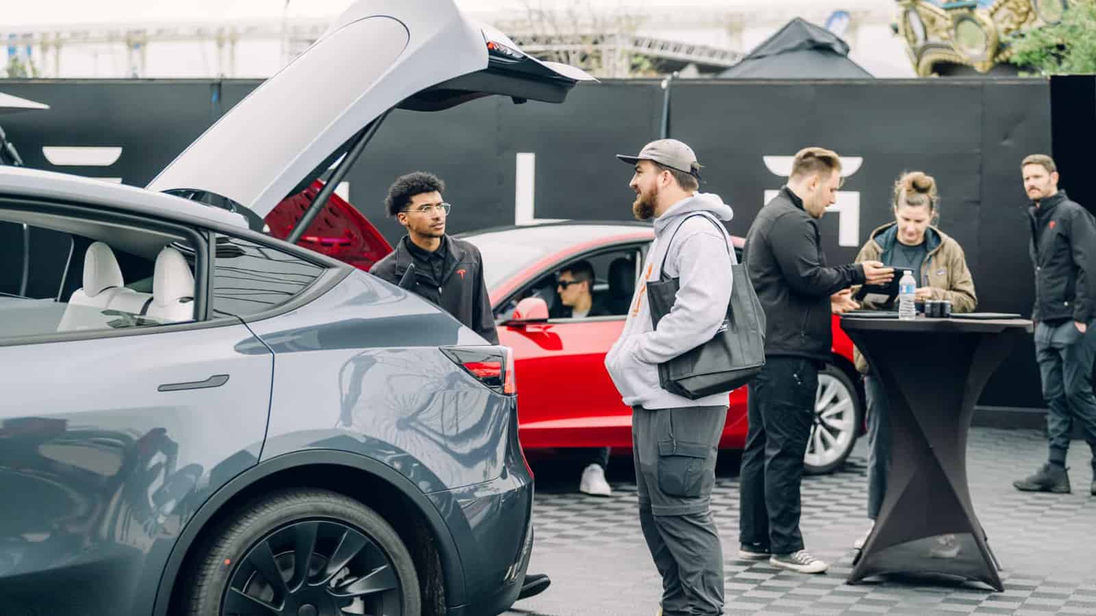 Image showcasing attendee at Electrify Expo speaking with a Tesla rep about the Tesla model Y