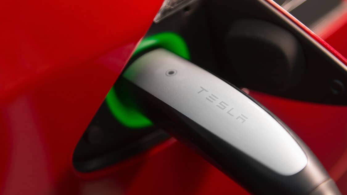 Image showcasing closeup of Tesla EV charging supercharger stations plug