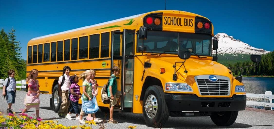 blue bird electric school bus with children getting on