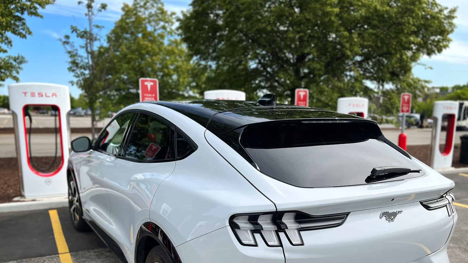 Ford Mustang Mach-E parked at Tesla Supercharger locations