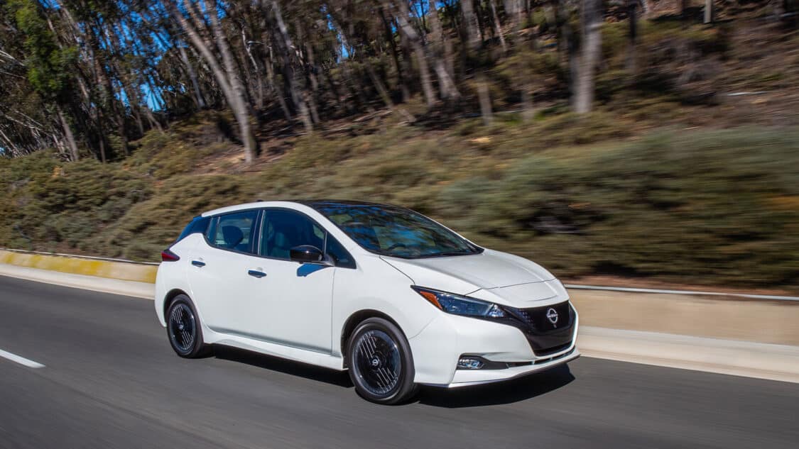 Nissan Leaf driving on road, side front view, inexpensive used electric cars