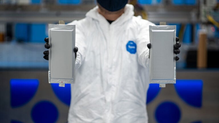Two solid-state batteries being held up by person in lab coat