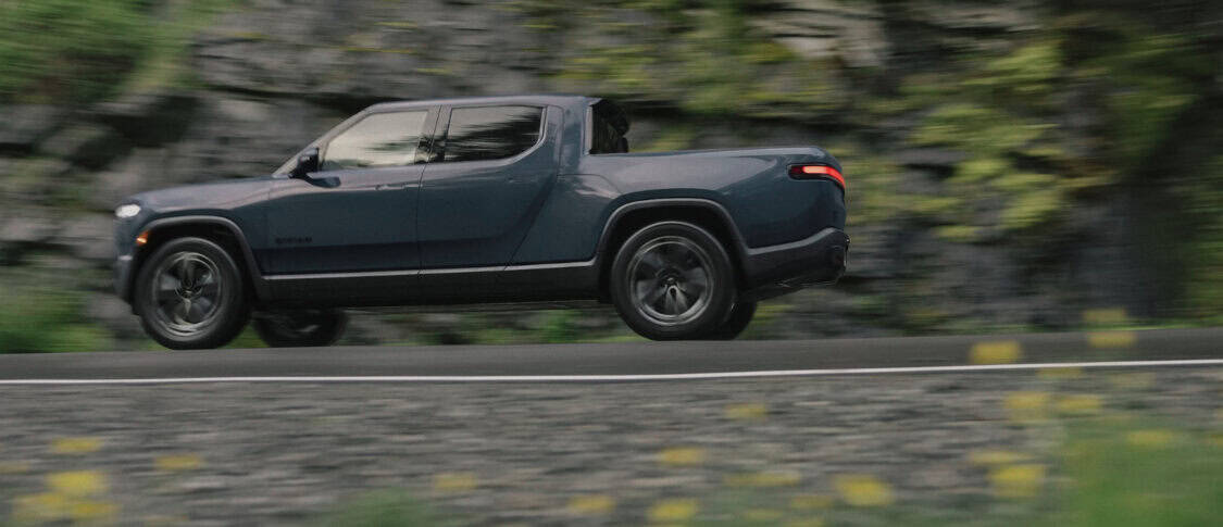 Rivian Tri Max R1T electric truck in Storm Blue with Darkout accents and 2022 All Terrain Wheels.