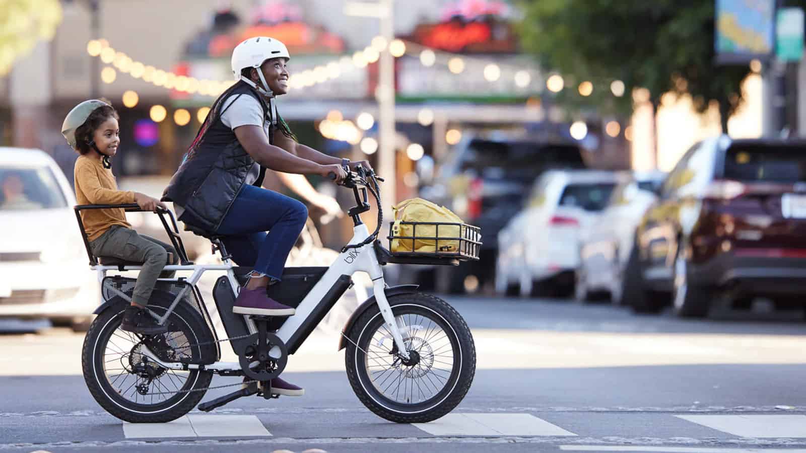 Woman riding Electric Cargo Bike with child in back cargo, Blix Dubble