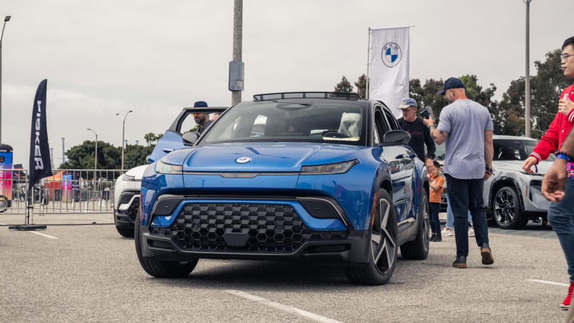 Blue Fisker Ocean electric SUV displayed at Electrify Expo in Long Beach California, surrounded by EV curious attendees.