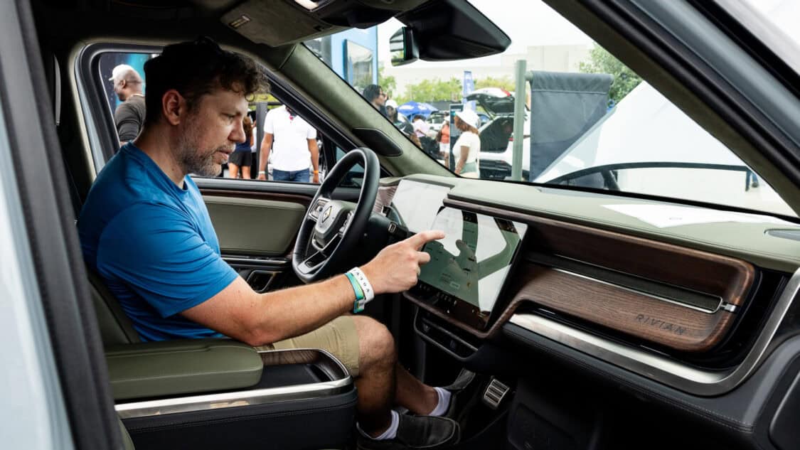 EV enthusiast checking out the features of the Rivian R2 at Electrify Expo.