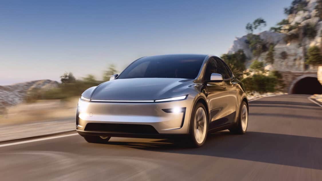 2025 Tesla Model Y Launch Series electric SUV driving on a scenic mountain road