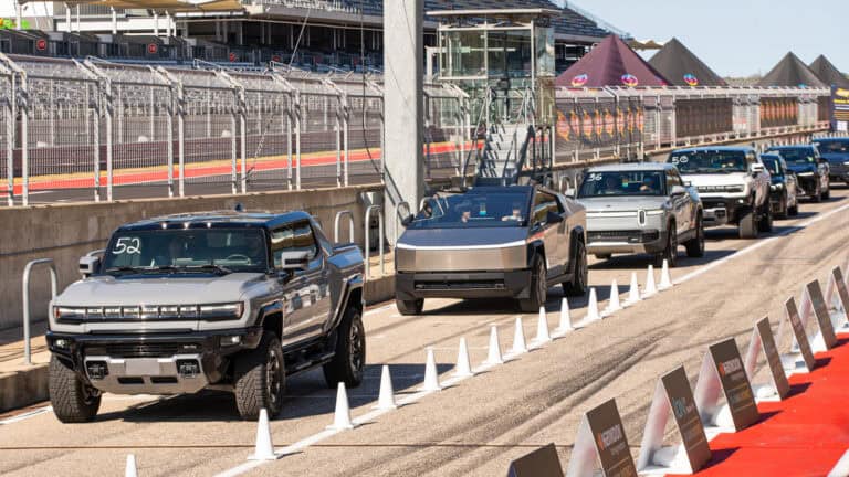 A lineup of electric pickup trucks at Electrify Expo, including the GMC Hummer EV, Tesla Cybertruck, and Rivian R1T