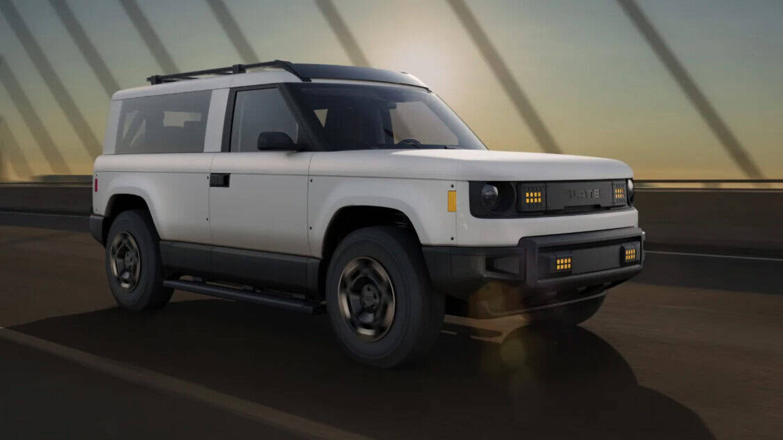 Slate Auto EV SUV in white driving on a bridge.