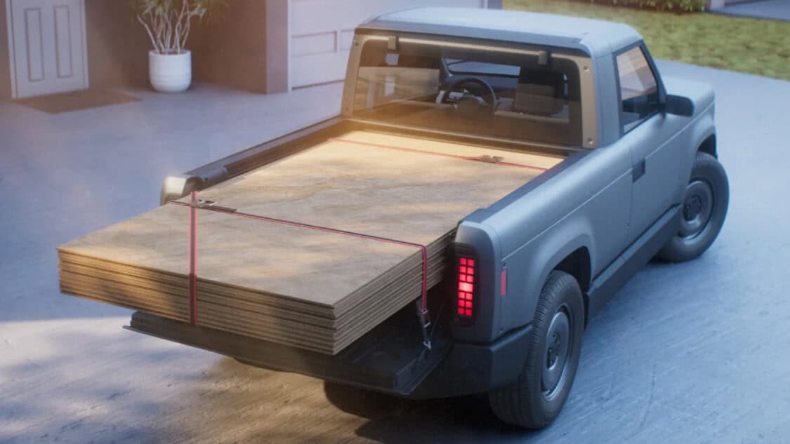 Slate Auto EV Truck with panels of wood loaded in truck's bed.