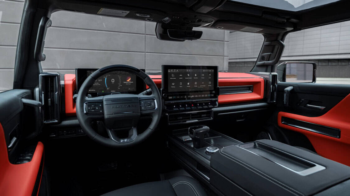 Front-facing view of the interior of the 2026 GMC Hummer EV Carbon Fiber Edition Pickup. Velocity Ember interior color shown.