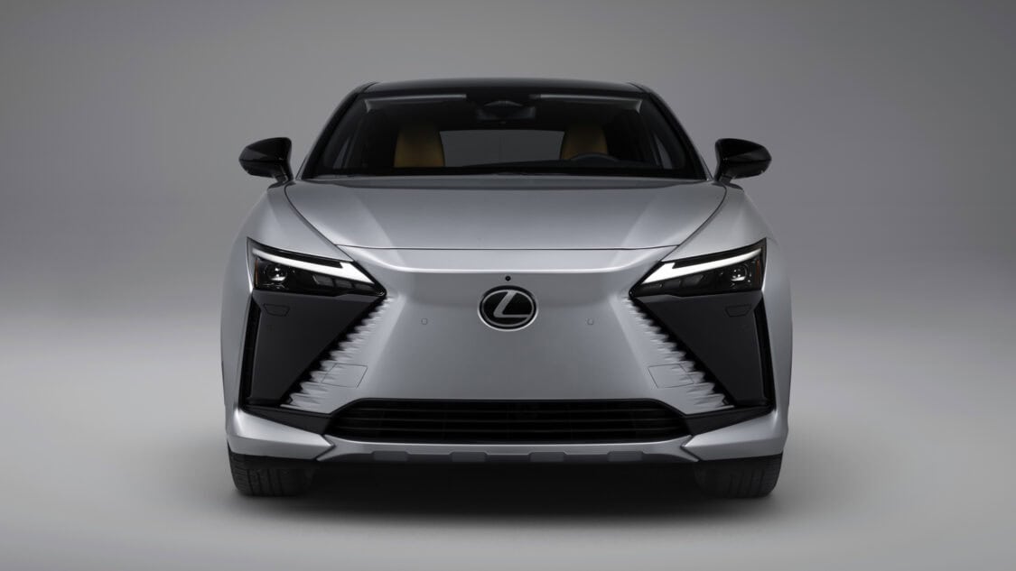 Front headlights view of a 2026 Lexus RZ 350e electric SUV in Wind color, light gray with subtle metallics.