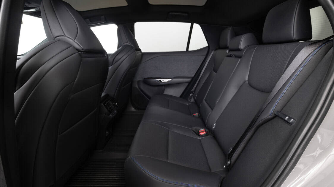Interior rear passenger view of a 2026 Lexus RZ 550e F SPORT electric SUV in Wind color, light gray with subtle metallics.