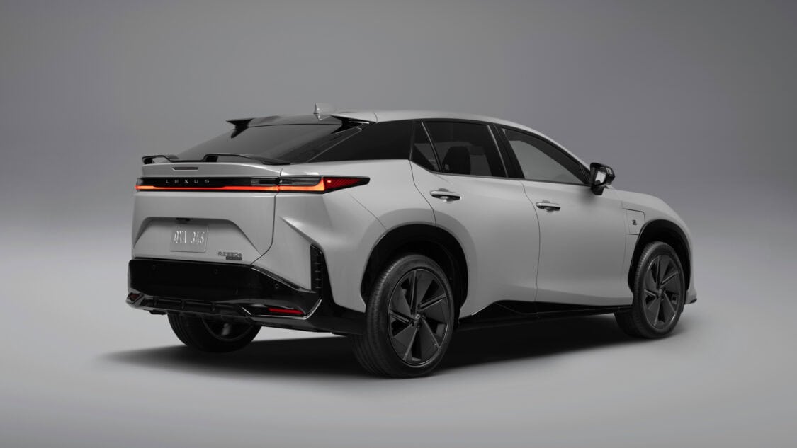 Rear three-quarter view of a 2026 Lexus RZ 550e F SPORT electric SUV in Wind color, light gray with subtle metallics.