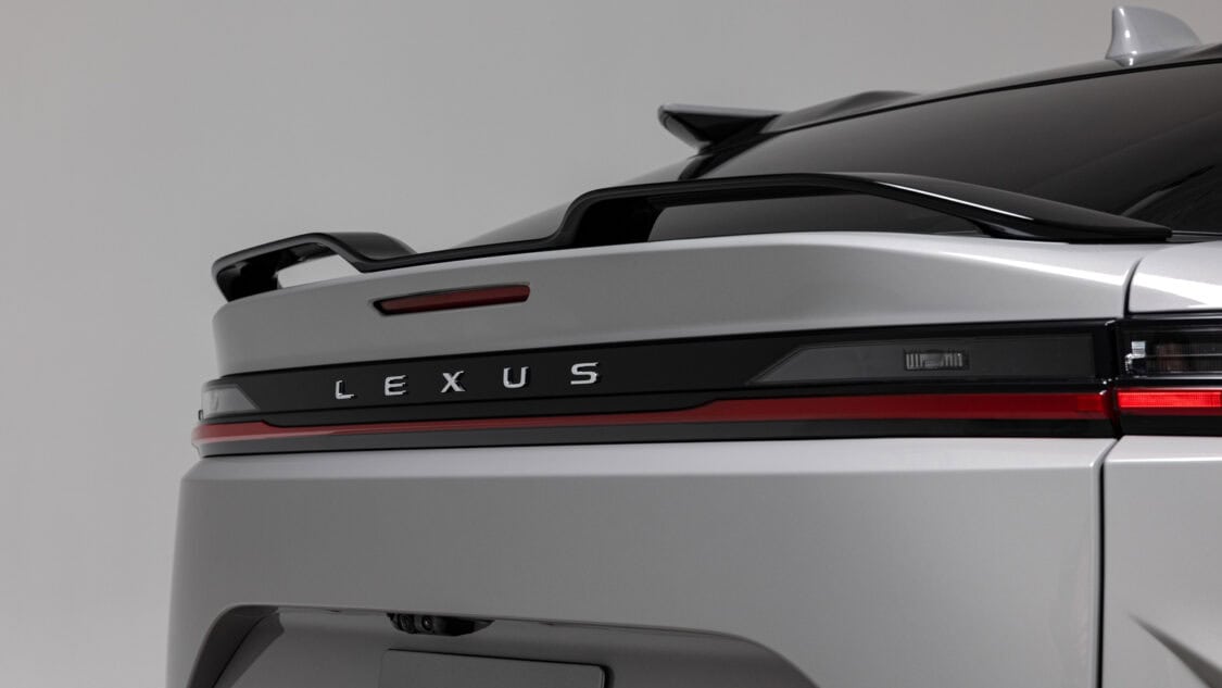 View of rear spoiler of a 2026 Lexus RZ 550e F SPORT electric SUV in Wind color, light gray with subtle metallics.