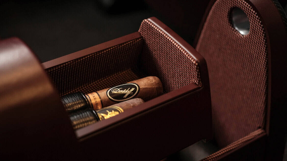 Luxury detail of the Hyundai Grandeur Heritage Series concept, featuring a custom storage drawer lined in textured fabric, holding premium cigars.