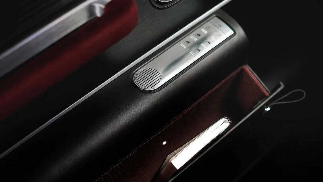 Detail of the Hyundai Grandeur Heritage Series door panel featuring metallic controls, burgundy velvet trim, and a clutch-inspired illuminated storage box.