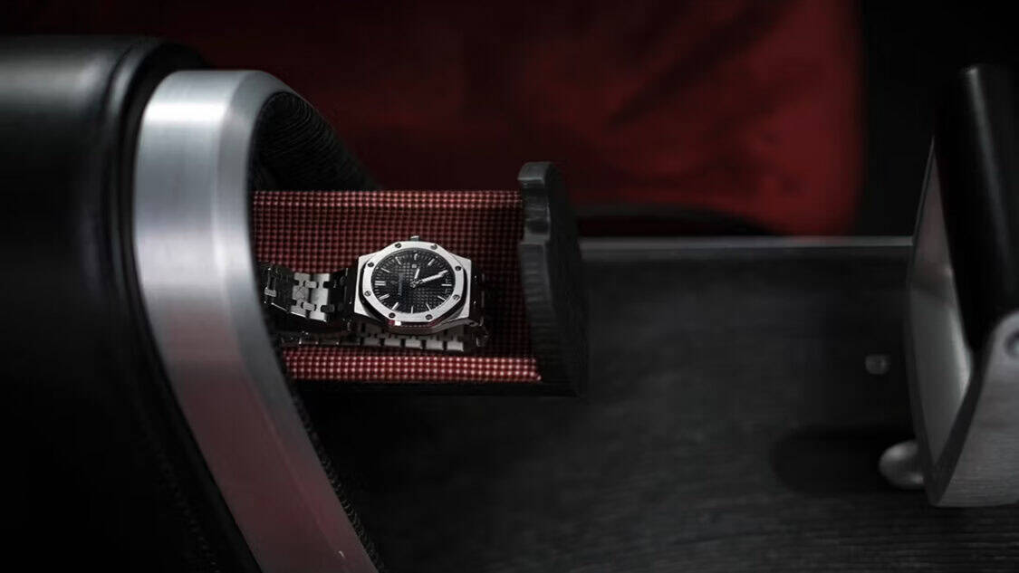 Close-up of the Hyundai Grandeur Heritage Series hidden storage compartment, featuring a luxury watch resting on patterned fabric inside the center console.