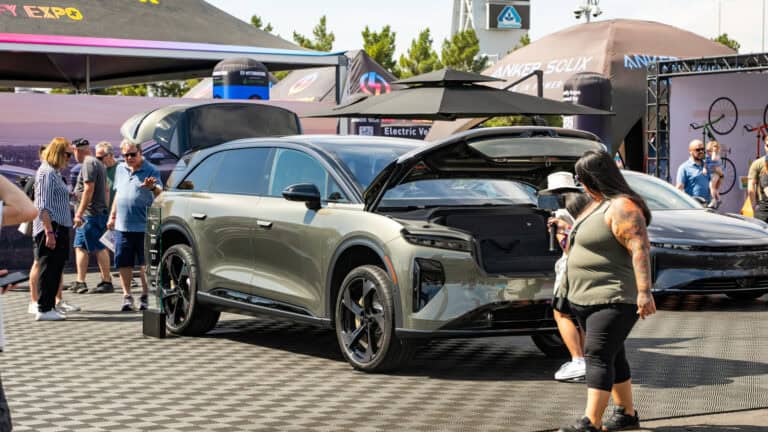Lucid Gravity SUV with front trunk open at Electrify Expo Phoenix, as attendees explore the vehicle and surrounding exhibits.